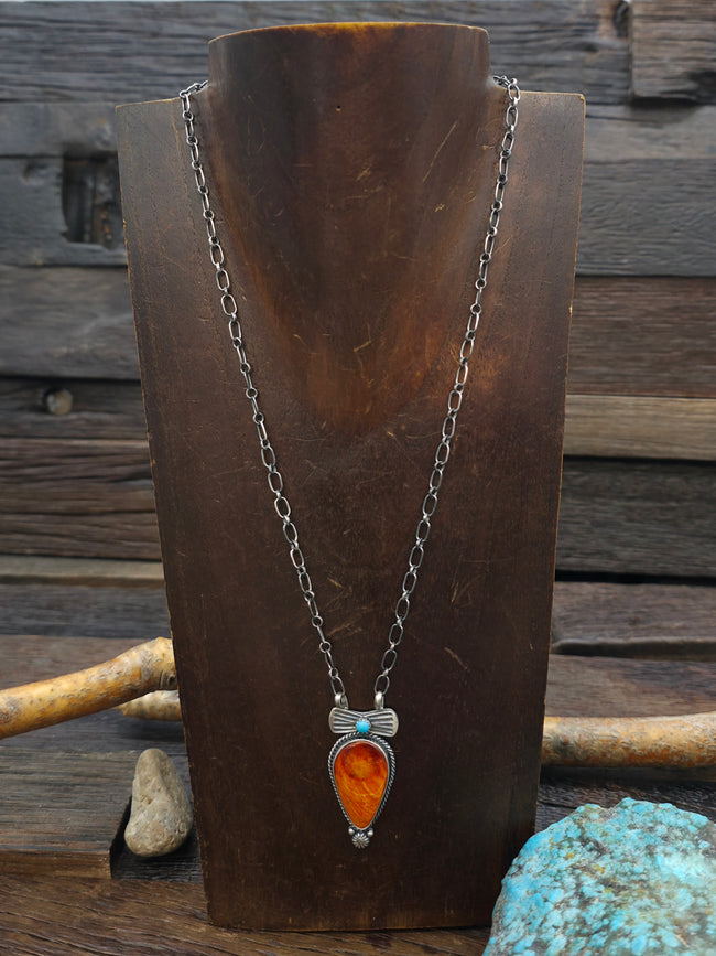 Necklace with a pendant on a wooden stand against a rustic background